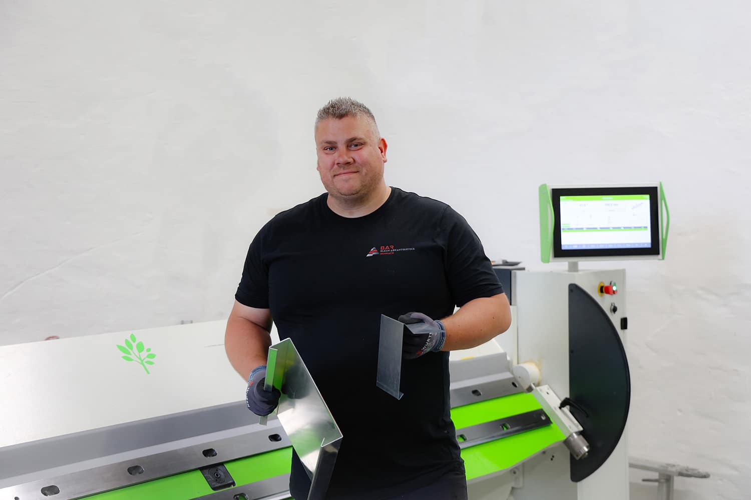 Marcel Rennack mit abgekantetem Blechprofil in der Werkstatt